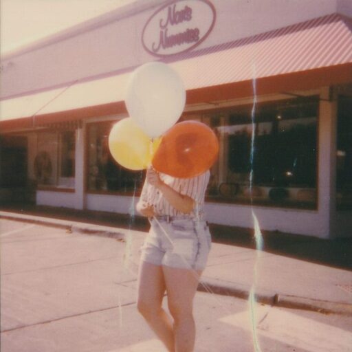 woman holding three balloons